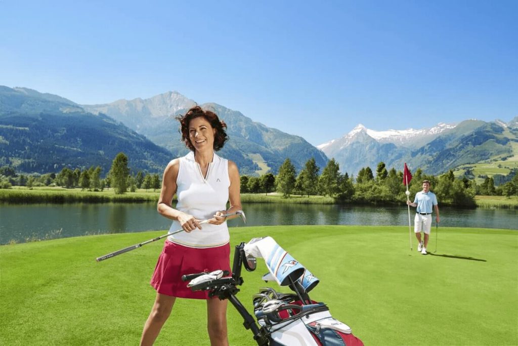 Golferin auf der Green-Landschaft mit Bergen im Hintergrund, Freizeitaktivität im Sommer.