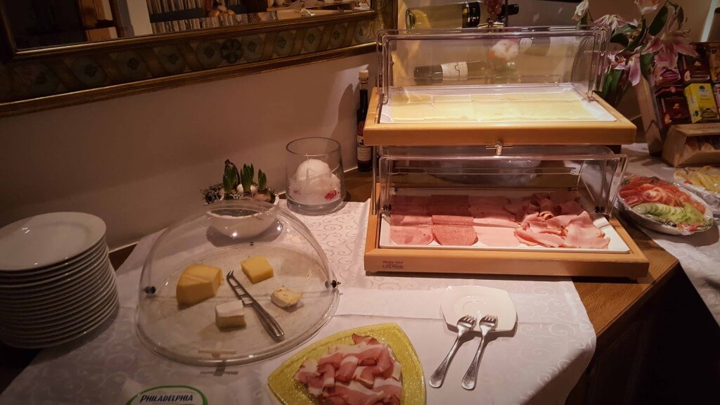 Vielfältiges Frühstücksbuffet mit Käse, Wurst, Gemüse und frischen Brötchen im Hotel Wolfgang.