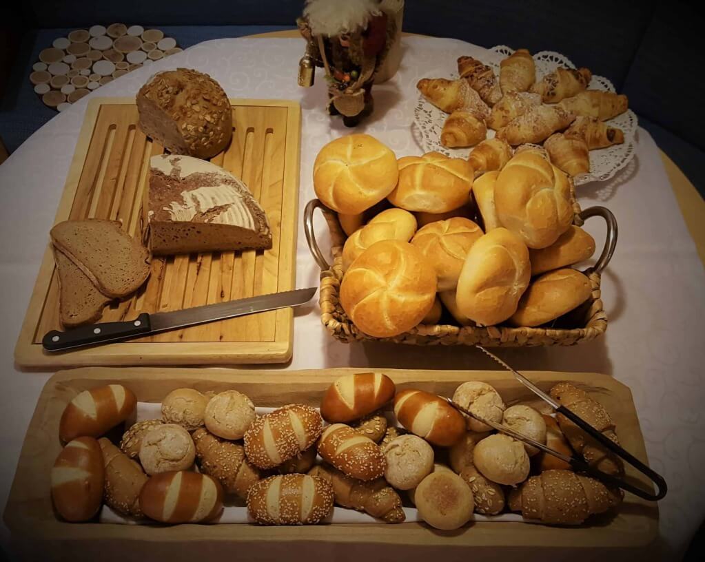 Vielfalt an frischen Brötchen und Brotsorten auf einem gedeckten Tisch im Hotel.