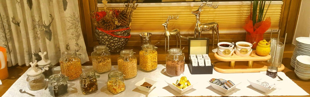 Frühstücksbuffet im Hotel Wolfgang mit Müsli, Marmelade und dekorativen Elementen.